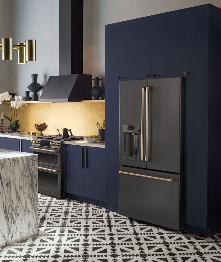 a modern kitchen with blue cabinets and marble counter tops, an island in the middle