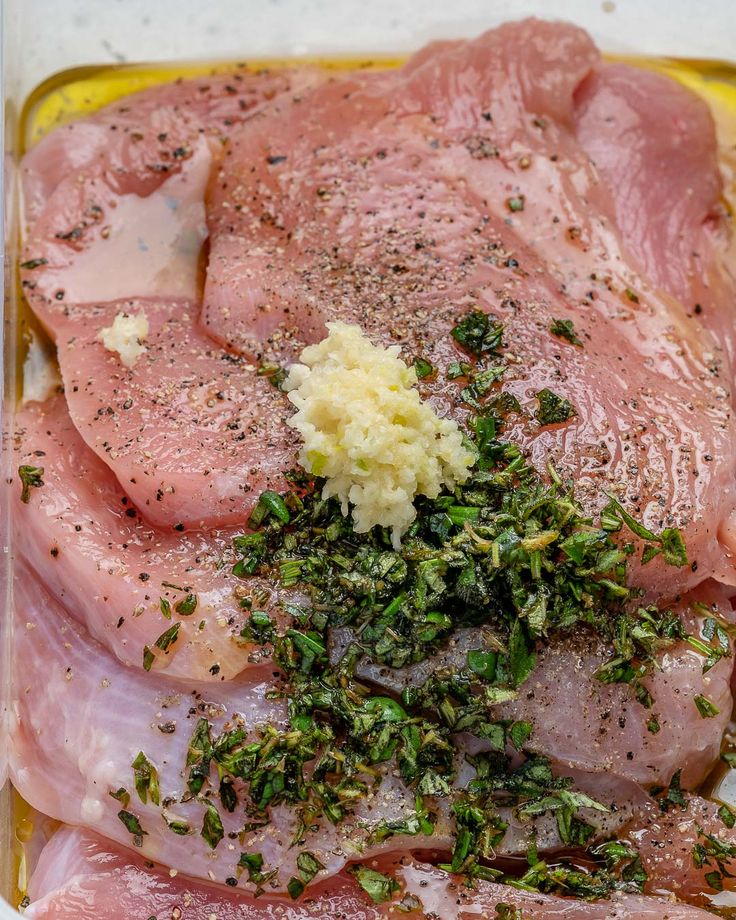 raw meat with herbs and seasoning in a glass dish