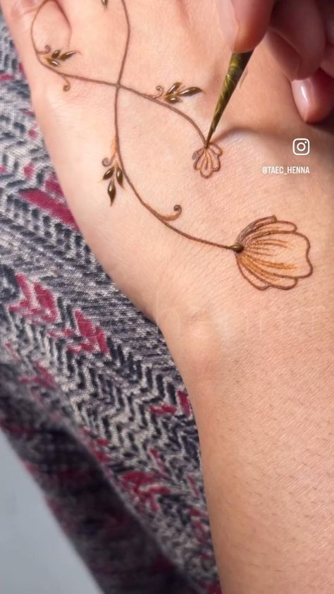 a woman with a tattoo on her arm and hand holding a pen in the shape of a heart