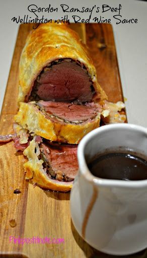 a roast beef sandwich cut in half with a cup of coffee next to it on a wooden cutting board