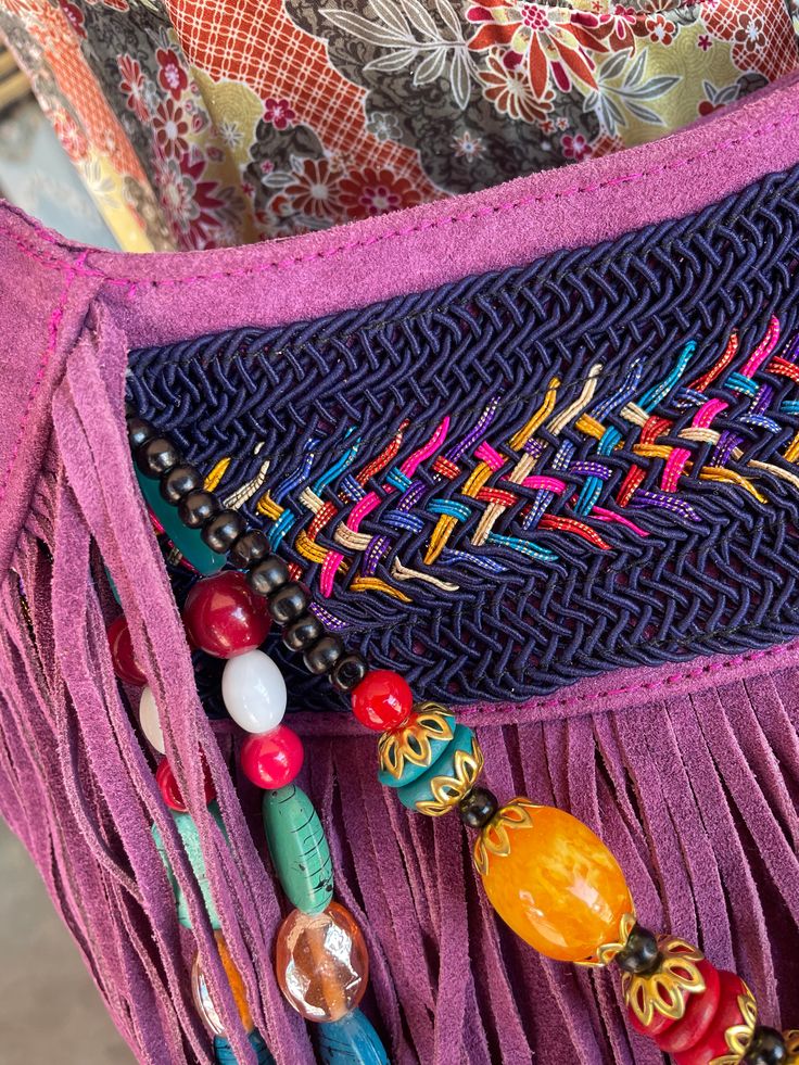 Orchid Leather Beaded Fringe Purse Each bag is unique and totally one of a kind! Room enough for all your daily essentials, this purse matches any bohemian style outfit and more. Featuring tassel and bead details, and so much fun fringe! Approx. 13" x 12" x 3" Zipper closure, 1 inside zipper pocket Bohemian Beaded Shoulder Bag For The Beach, Bohemian Beaded Shoulder Bag For Beach, Purple Beaded Shoulder Bag For Everyday Use, Bohemian Handmade Pink Shoulder Bag, Bohemian Leather Bags As Fashion Accessory, Bohemian Beaded Bags, Bohemian Festival Bags With Beaded Fringe, Handmade Purple Bags For Festival, Bohemian Leather Bags