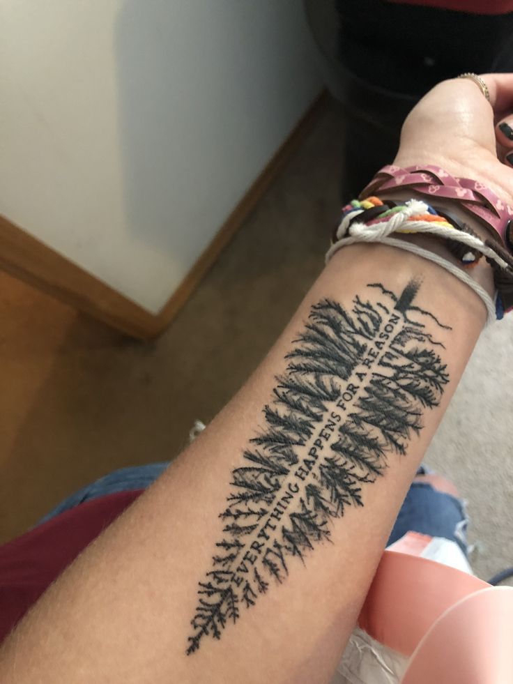 a person with a tattoo on their arm that has a fern leaf design on it