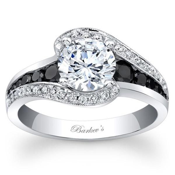 an engagement ring with black and white diamonds on the band, set in 18k white gold