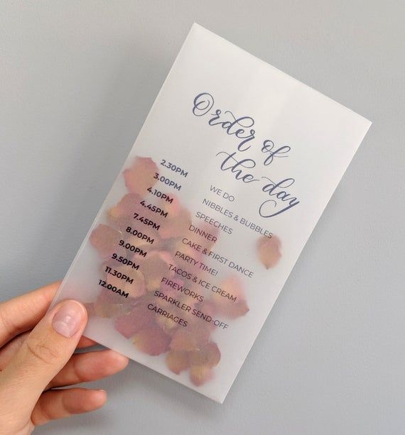 a person holding up a piece of paper with the words order of the day written on it