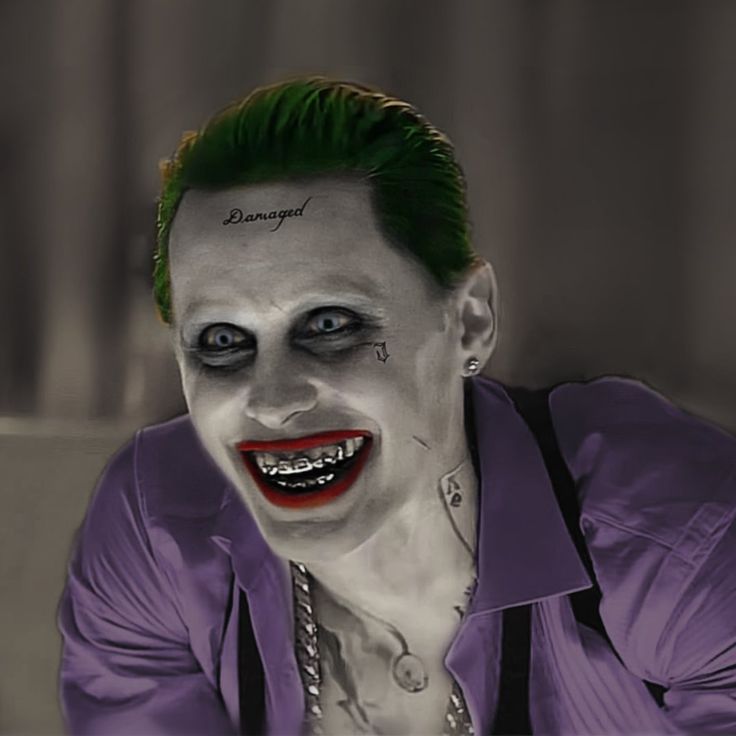 a man dressed as the joker with green hair and piercings on his face is posing for a photo