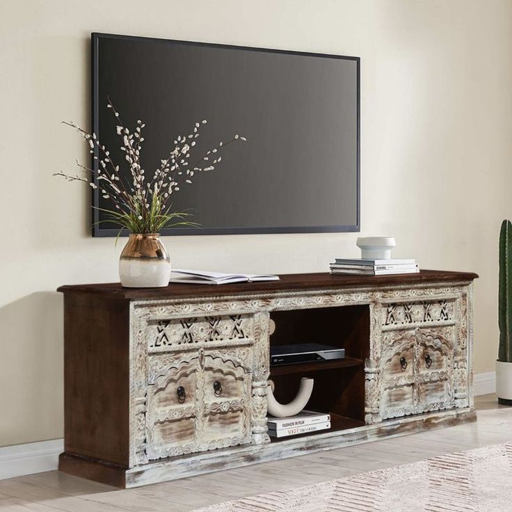 an entertainment center in the corner of a room with a large screen on the wall