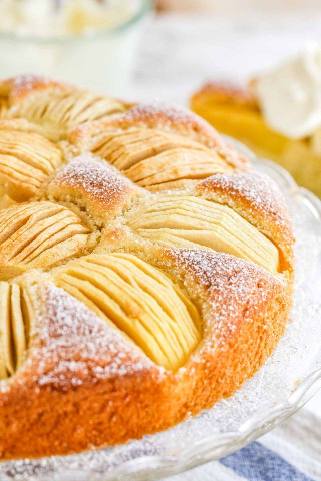 a close up of a cake on a plate with icing and powdered sugar