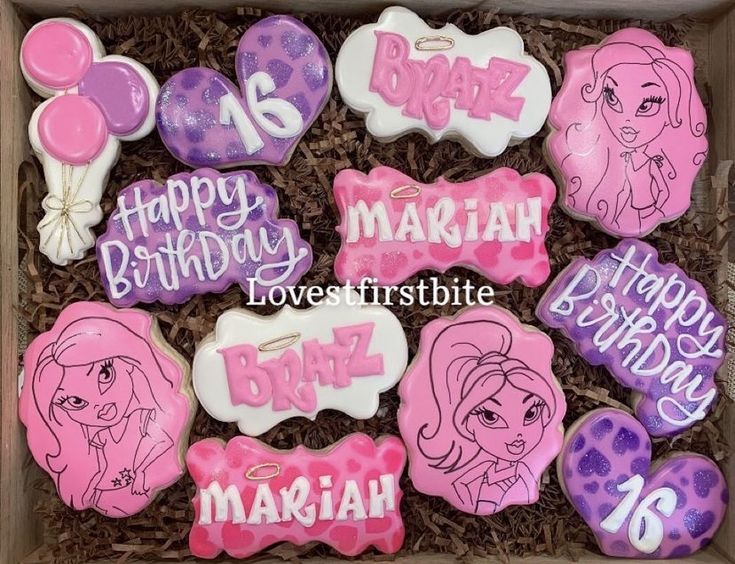 decorated birthday cookies in a box with pink and purple designs