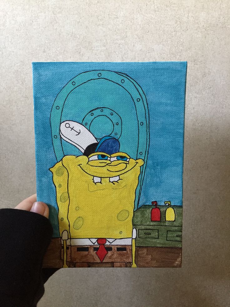 a hand holding up a painting of spongebob