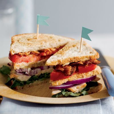 a cut in half sandwich sitting on top of a wooden plate