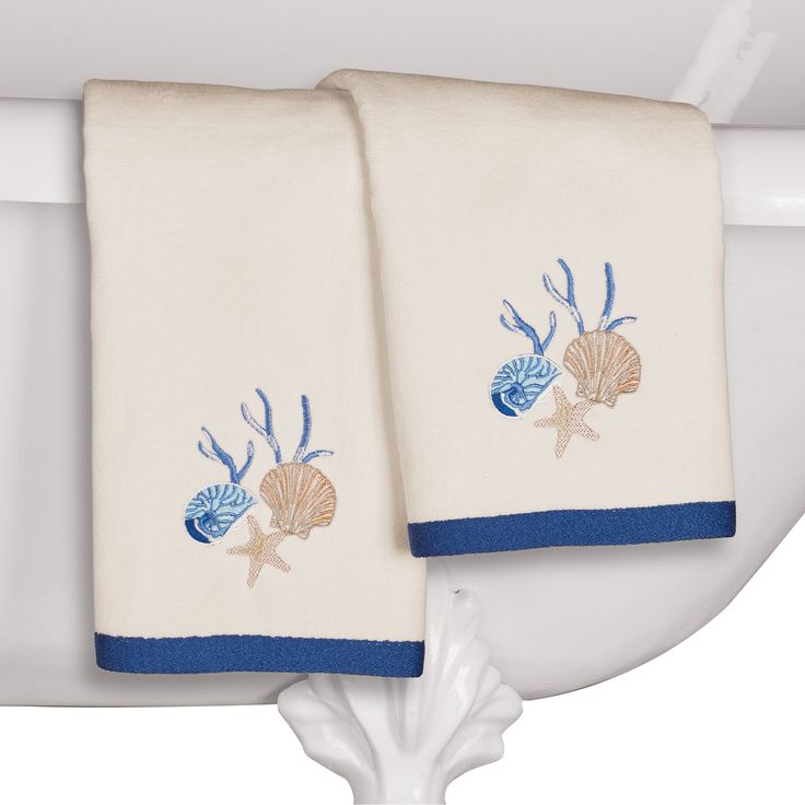 two towels are hanging on the edge of a bathtub in front of a wooden floor