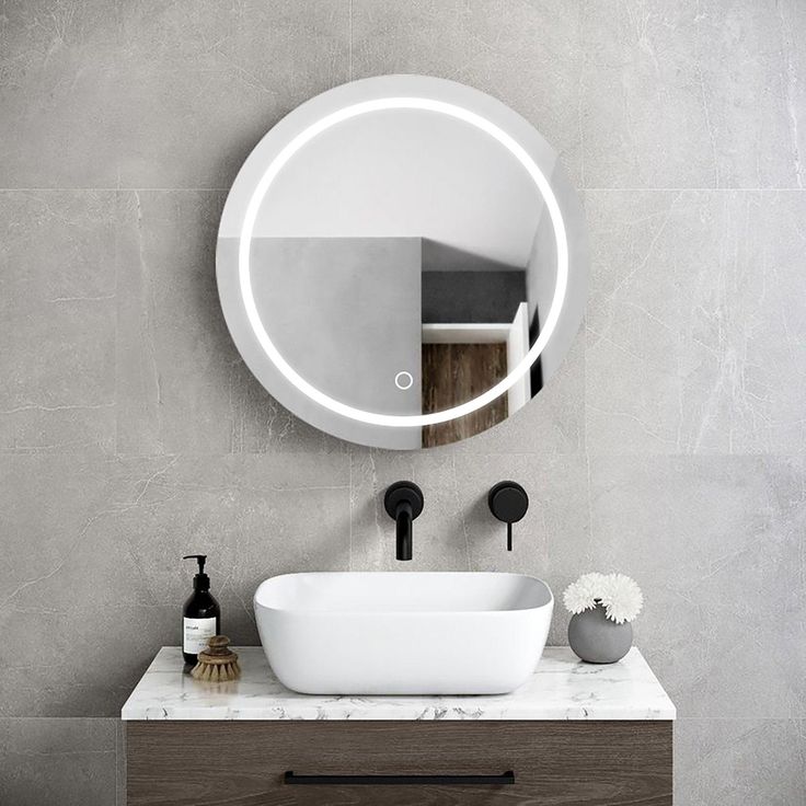 a bathroom with a sink, mirror and soap dispenser on the counter