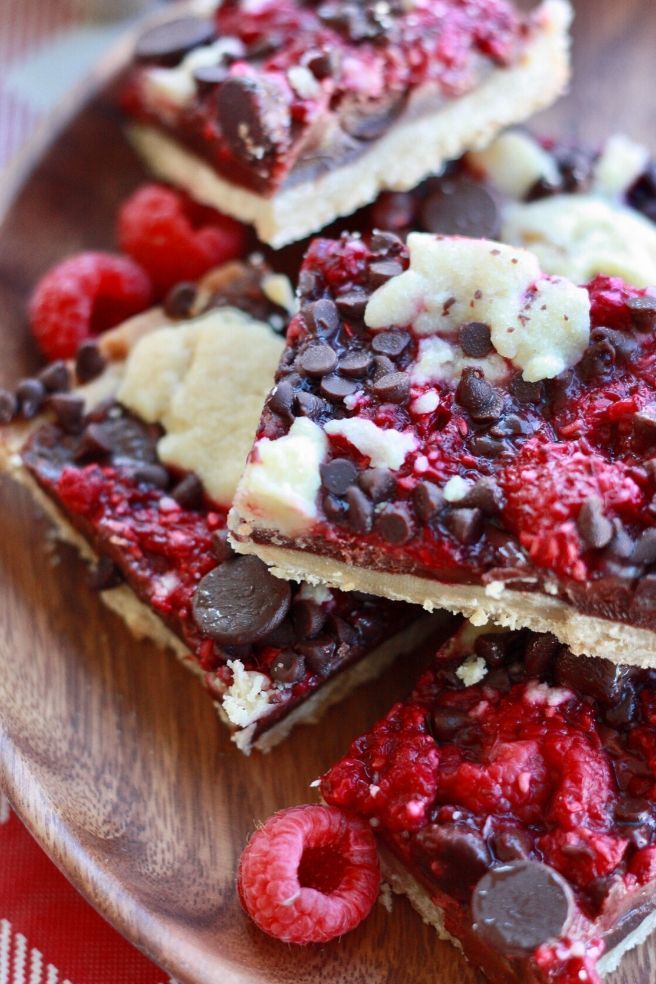 chocolate and raspberry bars on a wooden plate