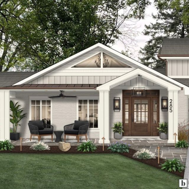 a small white house with two front porches and chairs on the lawn in front of it