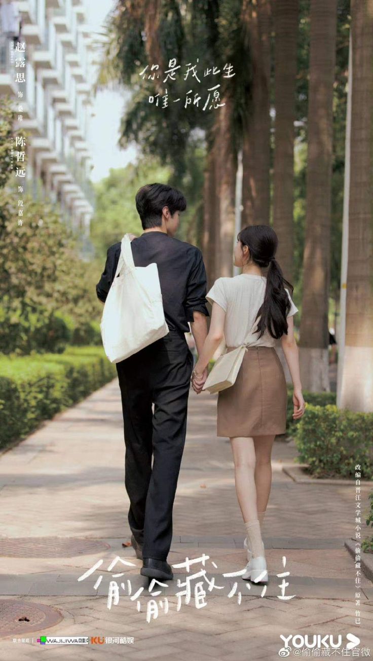 a man and woman holding hands walking down a sidewalk with trees in the back ground