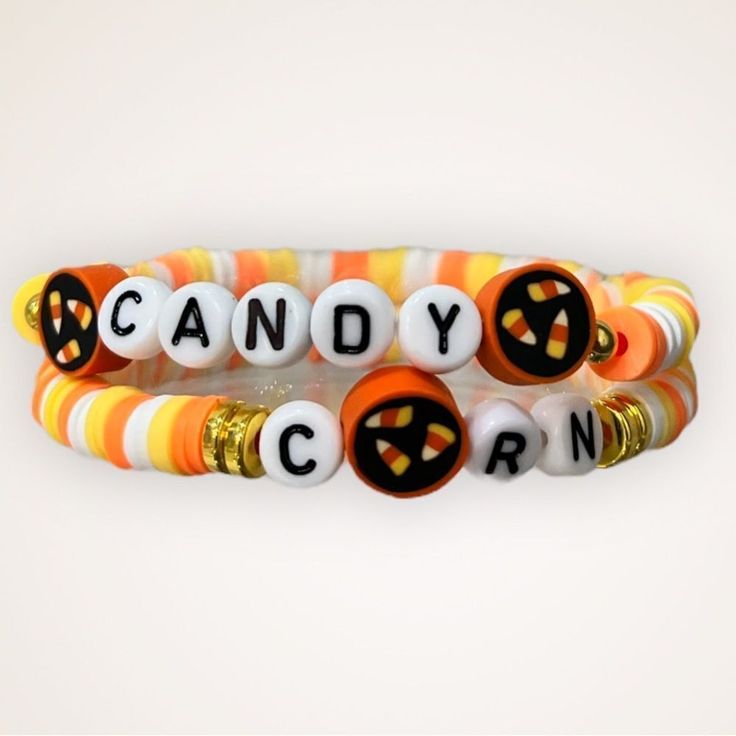 three bracelets with candy corn and jack - o'- lantern charms on them