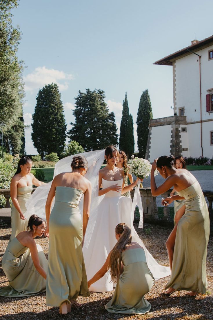 a group of women in dresses standing around each other