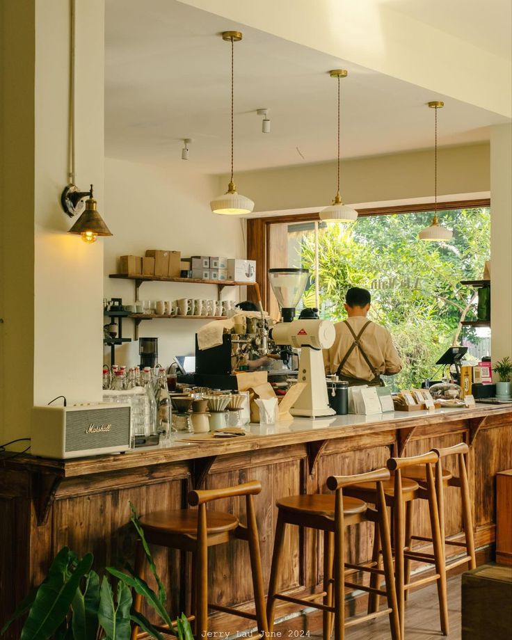 a man is behind the counter at a coffee shop