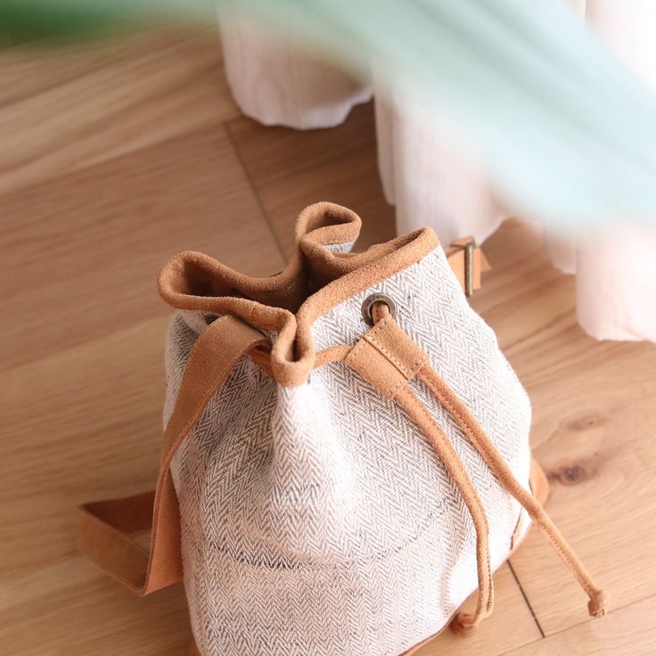 This handy drawstring bucket bag is a perfect fusion of traditional weaving with modern style. It is an easy and playful bag to store quite a bit. The shoulder straps and closures are made of suede leather with a beautiful finish. The bag closes by pulling the cord, like a pouch bag. This lightweight and body-friendly bag can be worn cross-body or over the shoulder with a long or short drop, thanks to its adjustable strap. The sturdy bottom base is slightly smaller while wider upwards, making it Natural Bucket Bag With Leather Handles For On-the-go, Canvas Bucket Bag With Adjustable Strap, Canvas Pouch Bucket Bag With Adjustable Strap, Brown Canvas Pouch Bucket Bag, Beige Canvas Pouch Bucket Bag, Everyday Leather Handle Pouch Bucket Bag, Brown Canvas Bucket Bag With Adjustable Strap, Natural Color Bucket Bag For On-the-go, Bucket Pouch Bag With Braided Handles For Errands