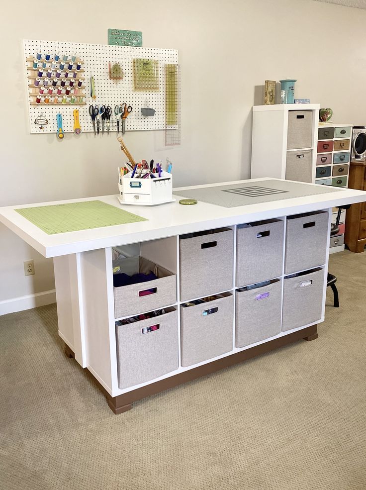 a craft room with several storage bins on the table