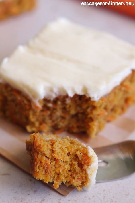 a piece of carrot cake with frosting next to a knife