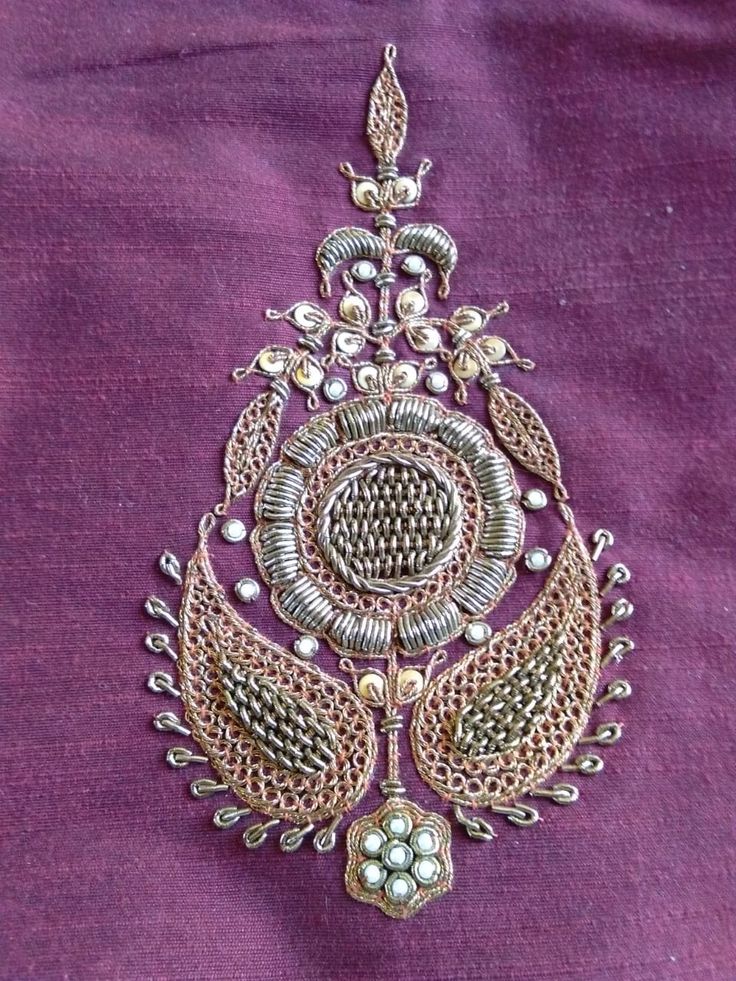 an intricately designed broochle on purple fabric