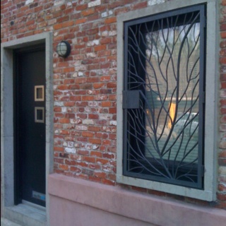 a brick building with a black door and window