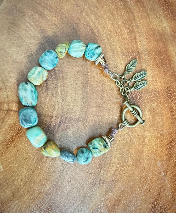 WOMEN'S TURQUOISE BRACELET  💎 Gemstone: Turquoise  🖌️ Style: Boho/ Western  🔗 Closure: Barrel & Torpedo  This bracelet is handmade with a beautiful Turquoise stone. Each gemstone is unique. It's a perfect bracelet for casual wear or for stacking with other bracelets for a boho/ western style.  ✨DETAILS:✨ 🔸Bracelet Size: Medium 7" inches 🔸Charms: Feathers  🔸Adjustable: Yes  🔸Material: Jewelry wire  🔸All bracelets come neatly packaged, ready to gift and are made with care. 🔸HOW TO MEASURE:  Measure just under the wrist bone with a fabric measuring tape and choose the size closest to your exact measurement to ensure you get the best fit.  🌴Thank you for visiting AromaOasisBoutique Handmade Turquoise Amazonite Bracelets, Bohemian Amazonite Bracelets With Gemstone, Bohemian Amazonite Gemstone Bracelets, Earthy Turquoise Beaded Bracelets With Gemstone Beads, Rustic Turquoise Beaded Bracelets With Natural Stones, Handmade Turquoise Chrysocolla Bracelets, Bohemian Bracelets With Natural Chrysocolla Stones, Earthy Turquoise Beaded Bracelets Hand Wrapped, Bohemian Beaded Amazonite Bracelet