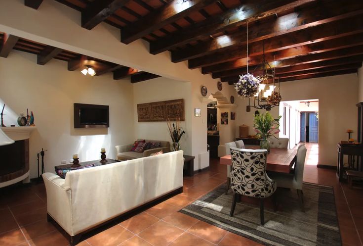 a living room filled with furniture and a flat screen tv on top of a wooden ceiling