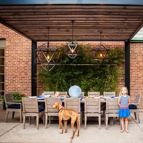 two children and a dog are sitting at a table with blue plates on it outside