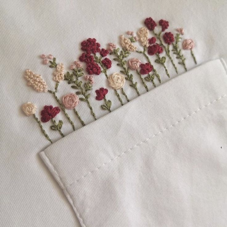 a close up of a piece of clothing with flowers on the front and back of it