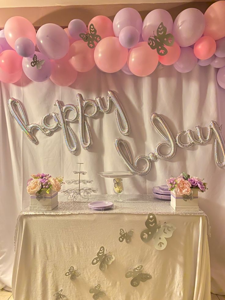 a table topped with lots of balloons next to a wall