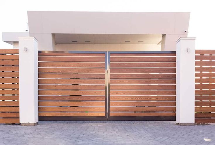 a large wooden gate with two white pillars