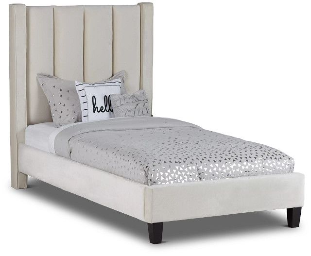 a white bed with an upholstered headboard and pillows on top of it