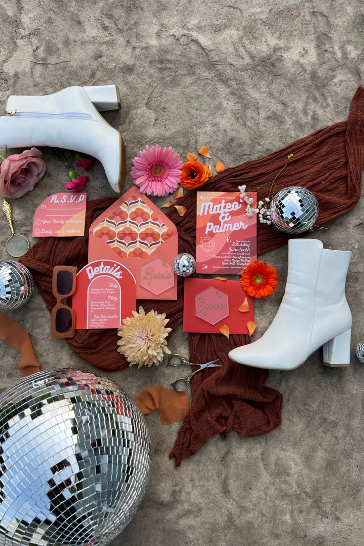 a table topped with lots of assorted items on top of a sandy floor next to a disco ball