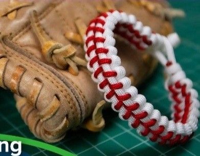 a baseball mitt with a red and white braided wristband next to it