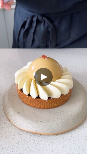 two cakes with icing on top sitting on a white table next to each other