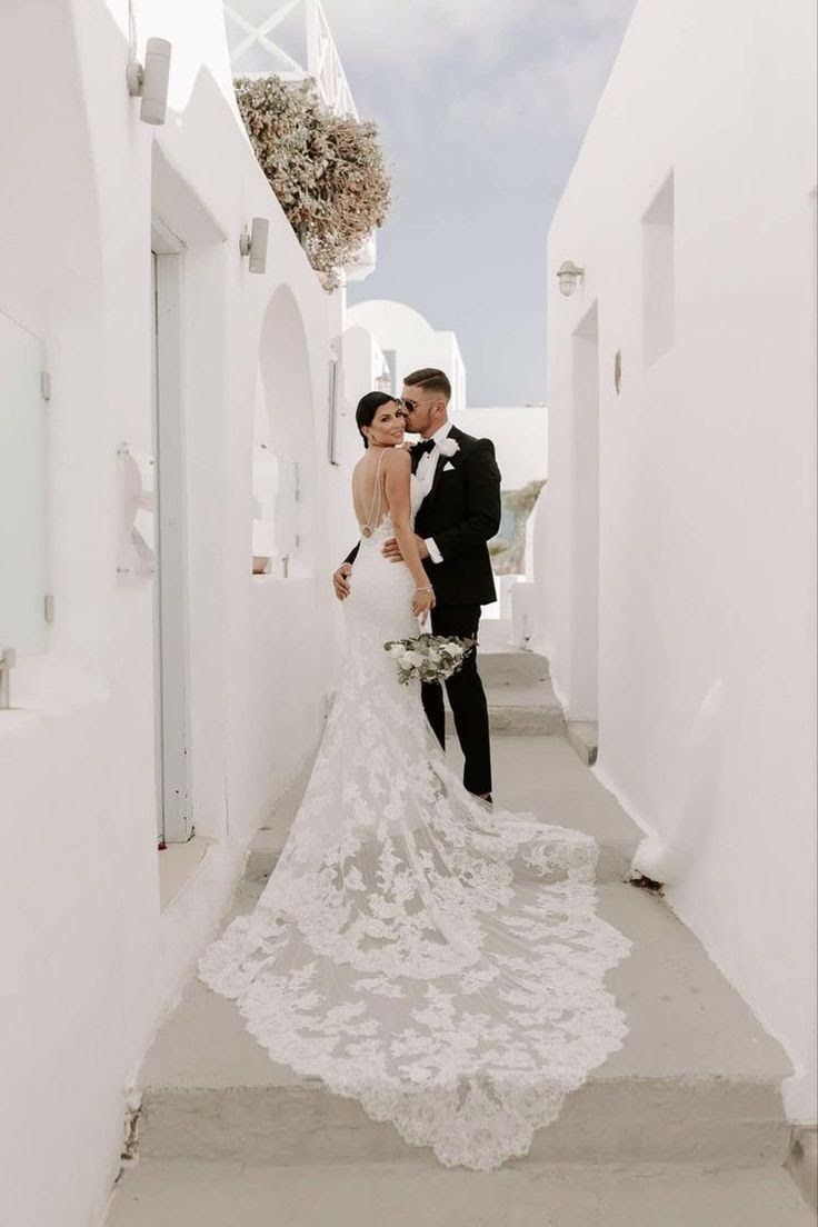 a bride and groom standing in an alley