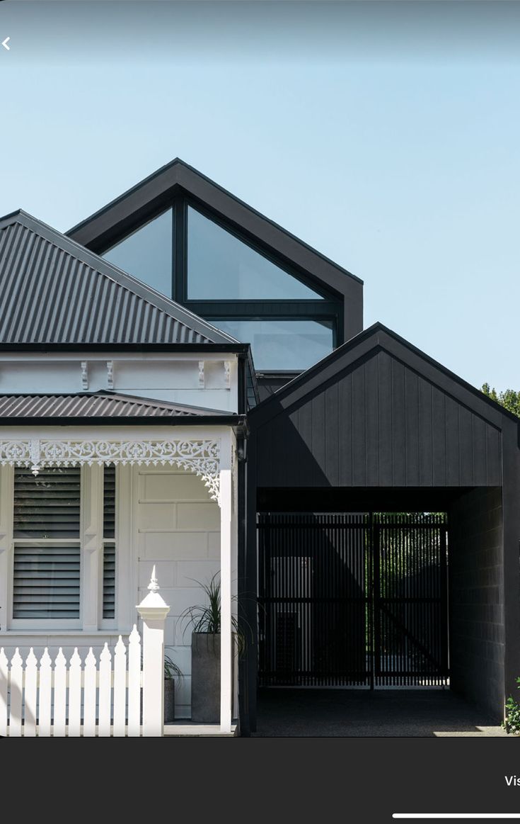 a black and white house with an awning over the front door is seen in this image