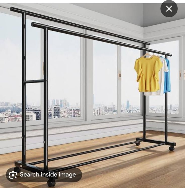 an empty room with two clothes racks and a t - shirt hanging on the rail