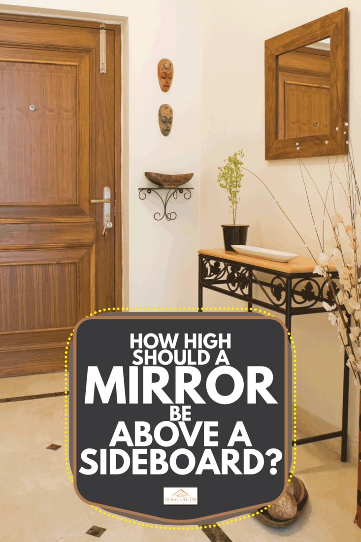 a sign that says how high should the mirror be above a sideboard? in front of a wooden door