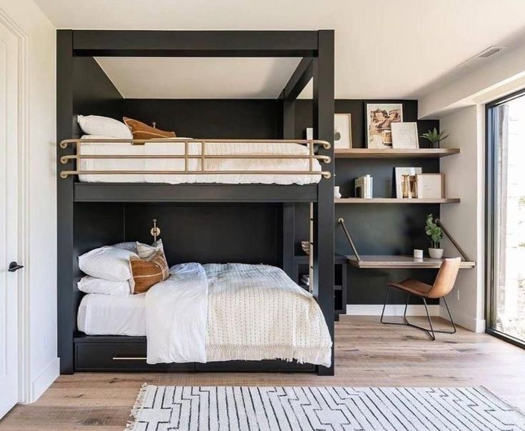 a bedroom with a bunk bed, desk and shelves on the wall next to it