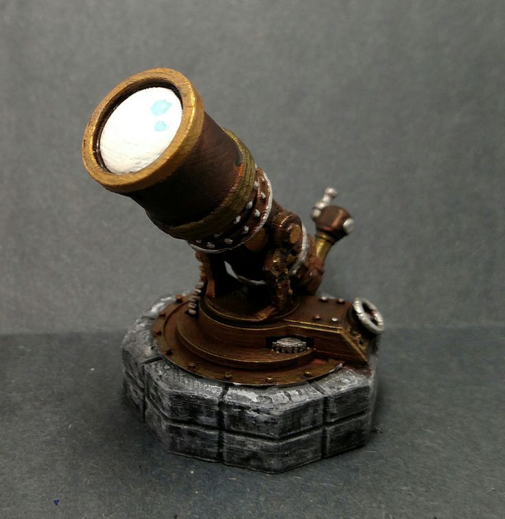 an old fashioned telescope on top of a piece of metal with a white light shining through it