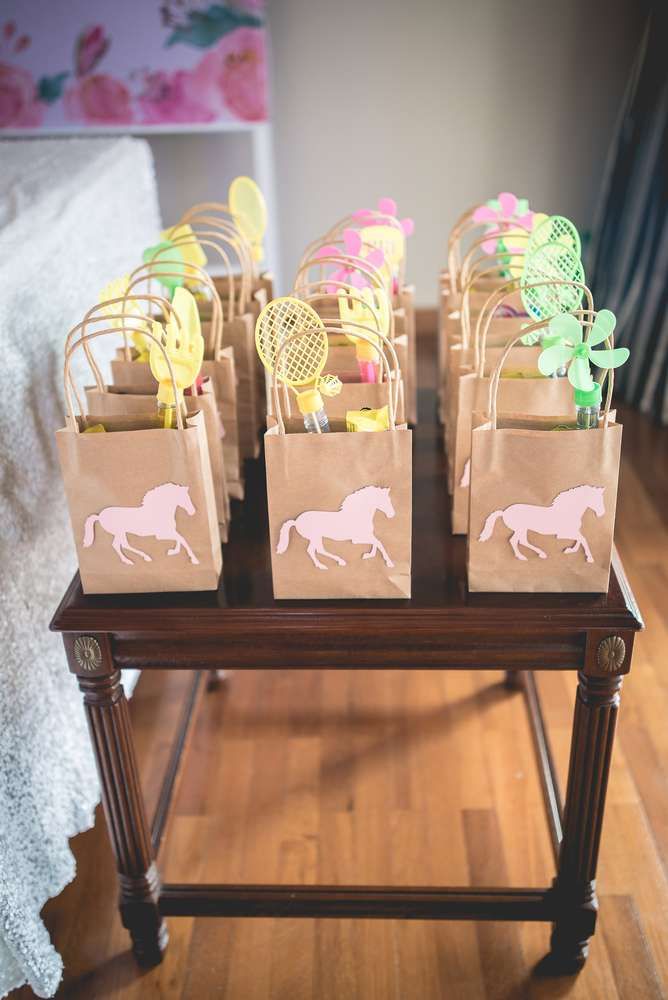 brown paper bags with pink and yellow horses on them sitting on a small wooden table