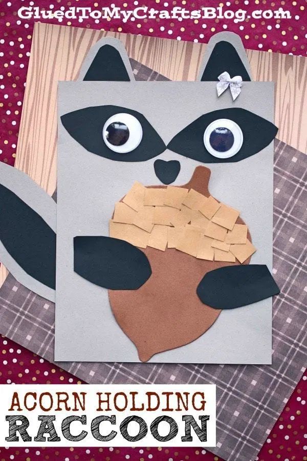 a raccoon made out of paper on top of a piece of cardboard with the words acorn holding an acorn