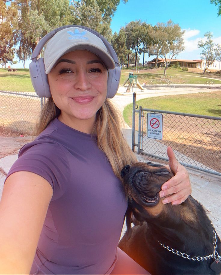 a woman wearing headphones and holding a dog