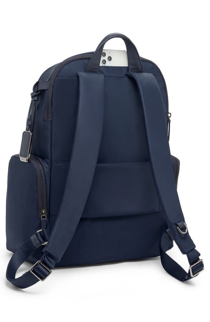 This travel-ready backpack features a handy Add-A-Bag sleeve for sliding onto suitcases along with a durable nylon design and well-organized interior. Top carry handle; adjustable backpack straps Two-way top-zip closure Exterior front zip pockets; side zip pocket; back smartphone pocket; back luggage sleeve Interior zip pockets; padded laptop pocket Nylon/leather Imported This bag includes Tumi Tracer®, an exclusive, complimentary program that helps reunite lost or stolen bags with their rightfu On-the-go Nylon Luggage With Adjustable Strap, Travel Laptop Bag With Anti-theft Pocket, Nylon Travel Bag With Adjustable Strap For Commuting, Functional Nylon Luggage With Adjustable Strap, Versatile Nylon Luggage With Adjustable Strap, Modern Nylon Luggage For On-the-go, Rectangular Nylon Luggage With Adjustable Strap, Nylon Backpack With Anti-theft Pocket For On-the-go, Nylon Laptop Backpack With Luggage Sleeve