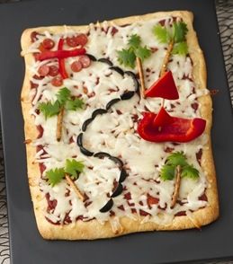 a square pizza on a plate with toppings next to a bowl of rice and vegetables