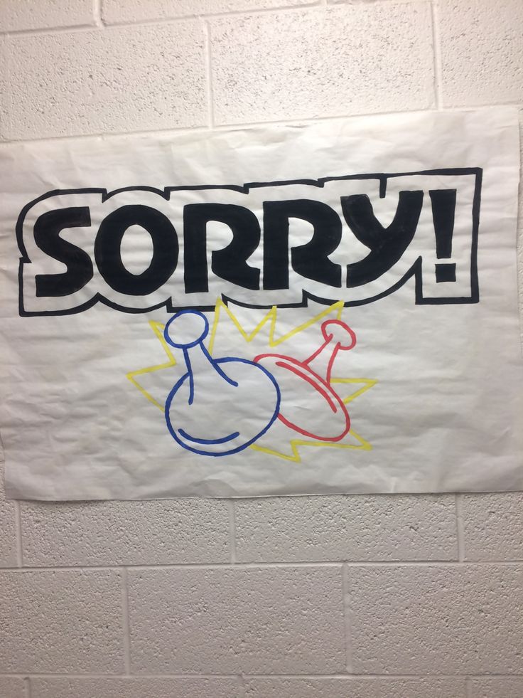 a sign that says sorry on it in front of a white brick wall with graffiti