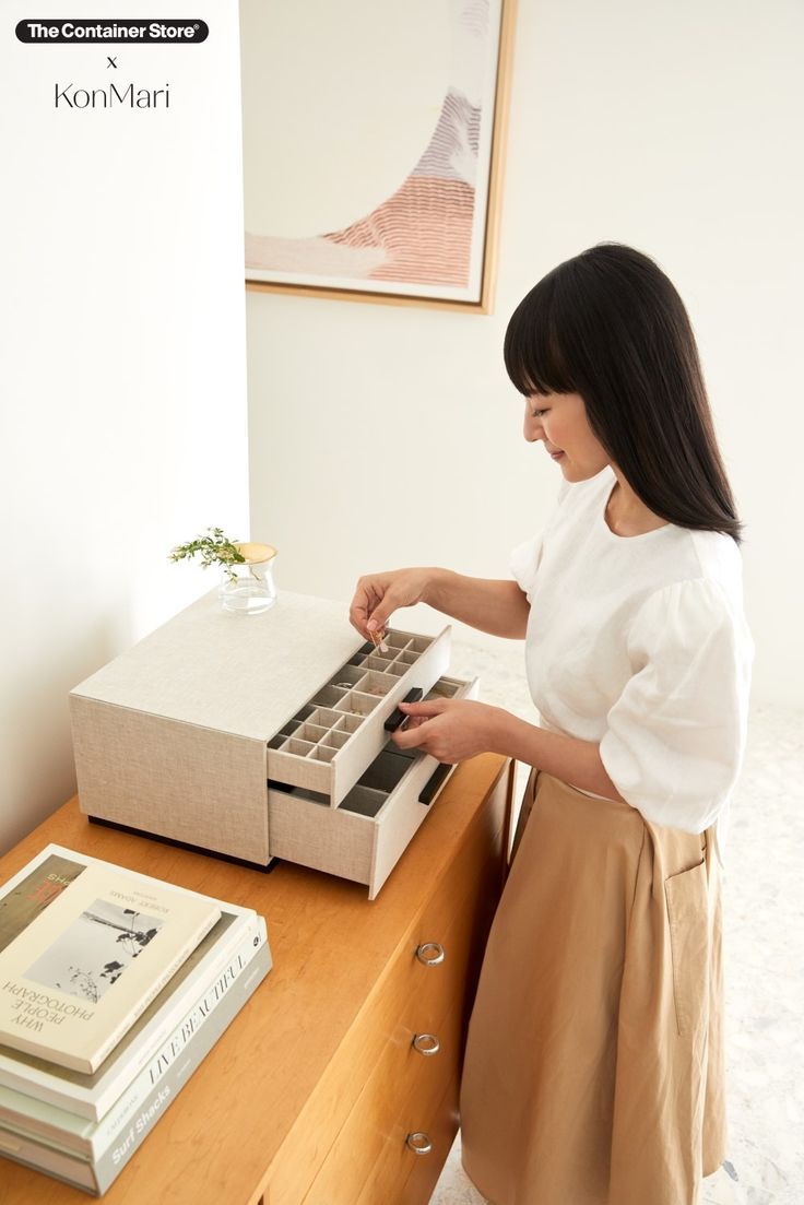 a woman standing in front of a desk with a calculator and books on it